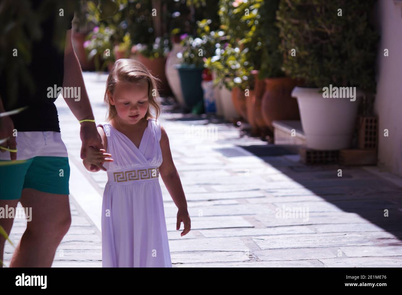 Crète, Grèce - 16 septembre 2017 : une petite fille en robe traditionnelle  grecque marchant tout en tenant un doigt de son parent. Petite fille  européenne Photo Stock - Alamy