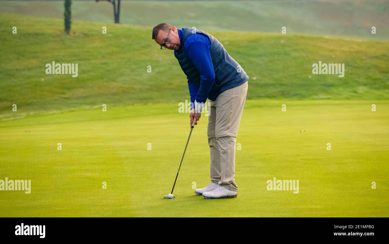Gros plan d'un joueur de golf qui a une poche de putt la balle sur le vert Banque D'Images