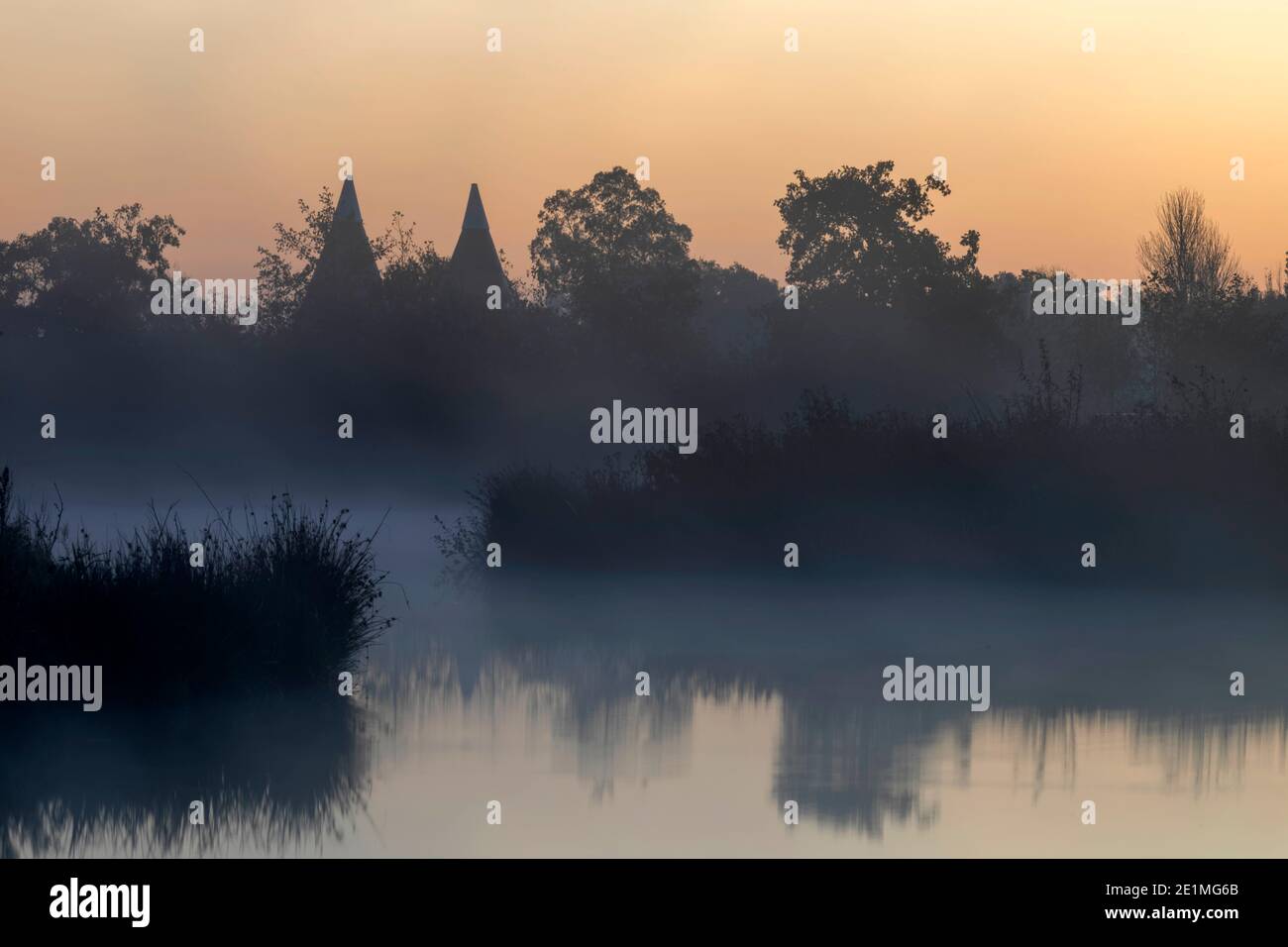 Angleterre, Kent, maisons d'Oast converties, alias Oasts et lac avec brume matinale près de Tunbridge Wells Banque D'Images