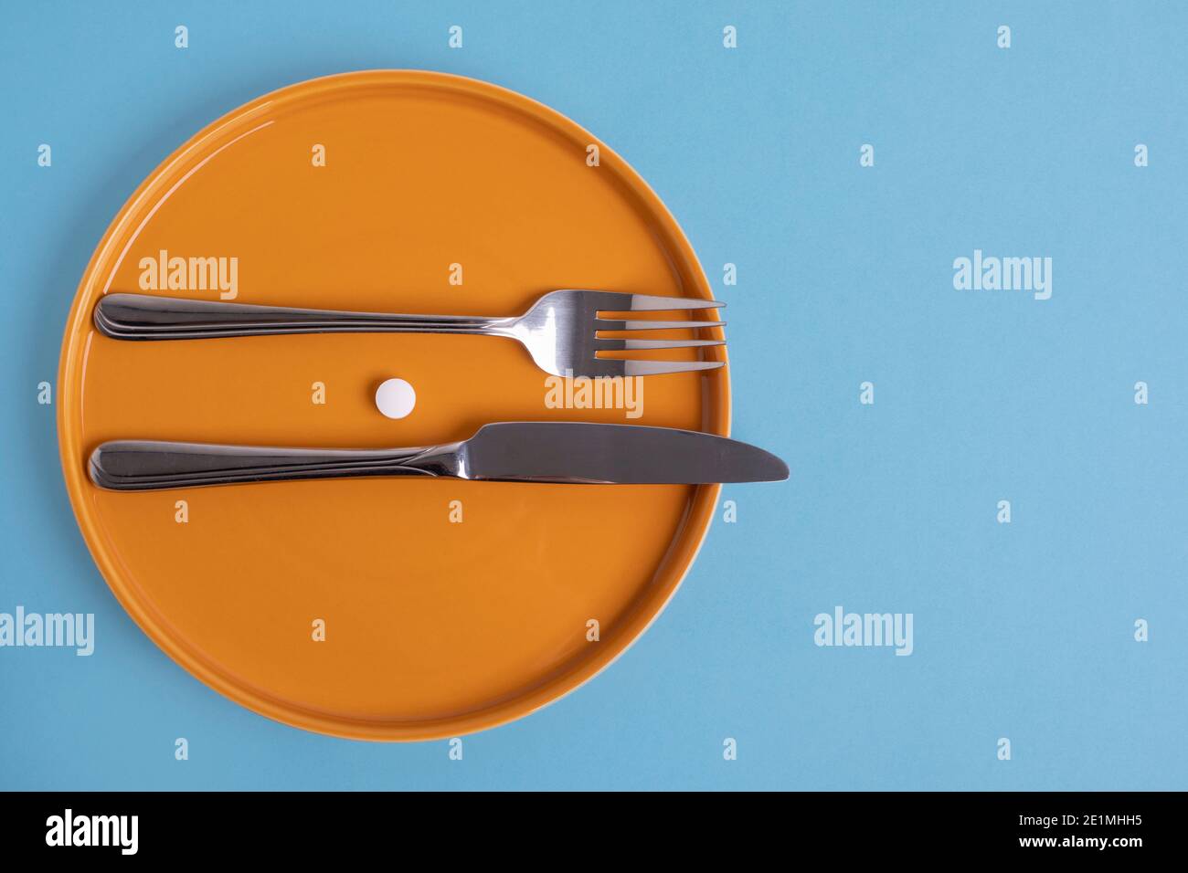 Assiette avec fourchette un couteau et une pilule sur fond bleu. Problème de dépendance comme concept Banque D'Images