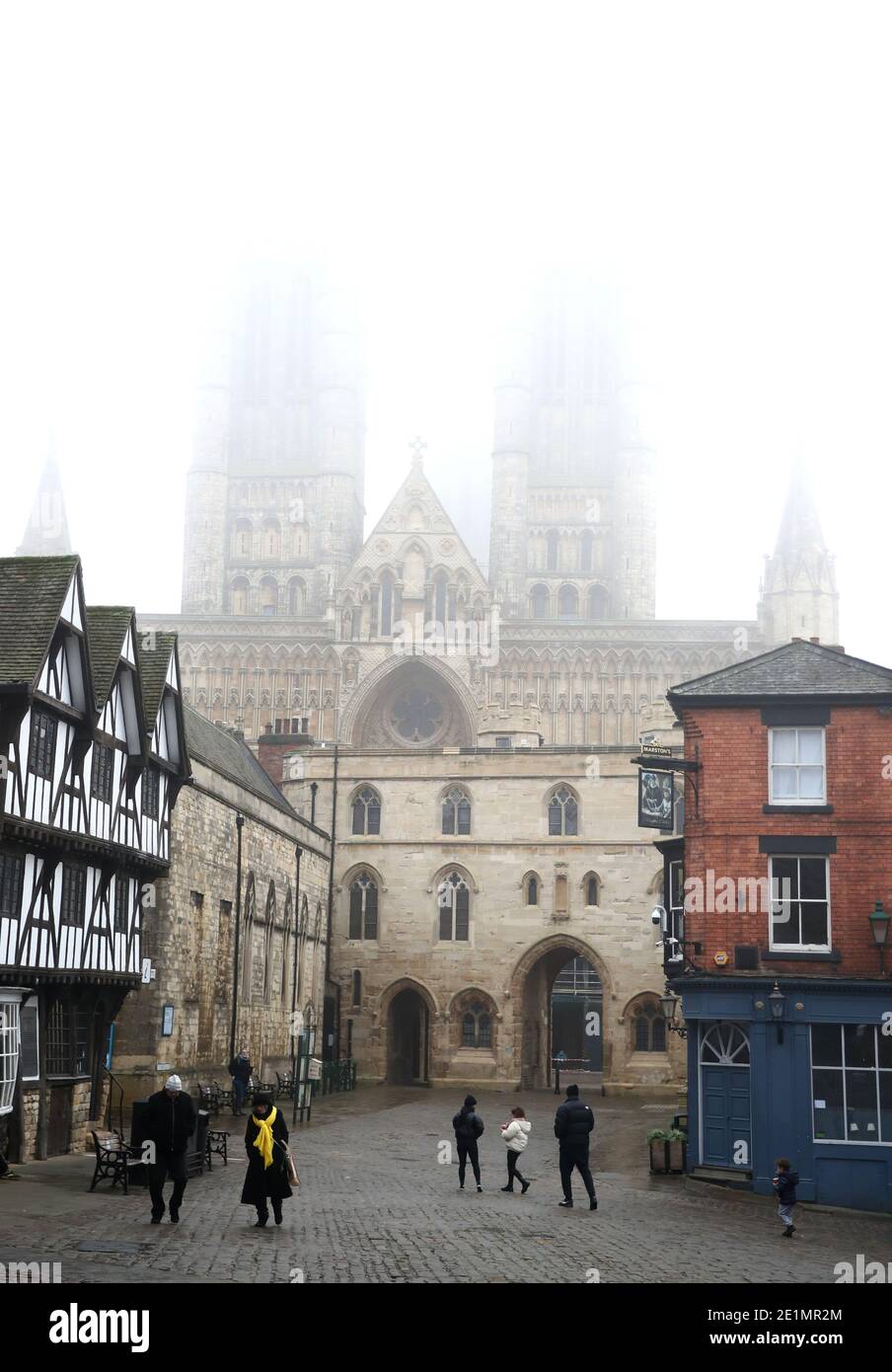 Les amateurs de shopping près de la cathédrale dans le centre-ville de Lincoln lors du troisième confinement national de l'Angleterre pour freiner la propagation du coronavirus. En vertu de mesures accrues, les gens ne peuvent plus quitter leur maison sans une excuse raisonnable et les écoles doivent fermer pour la plupart des élèves. Banque D'Images