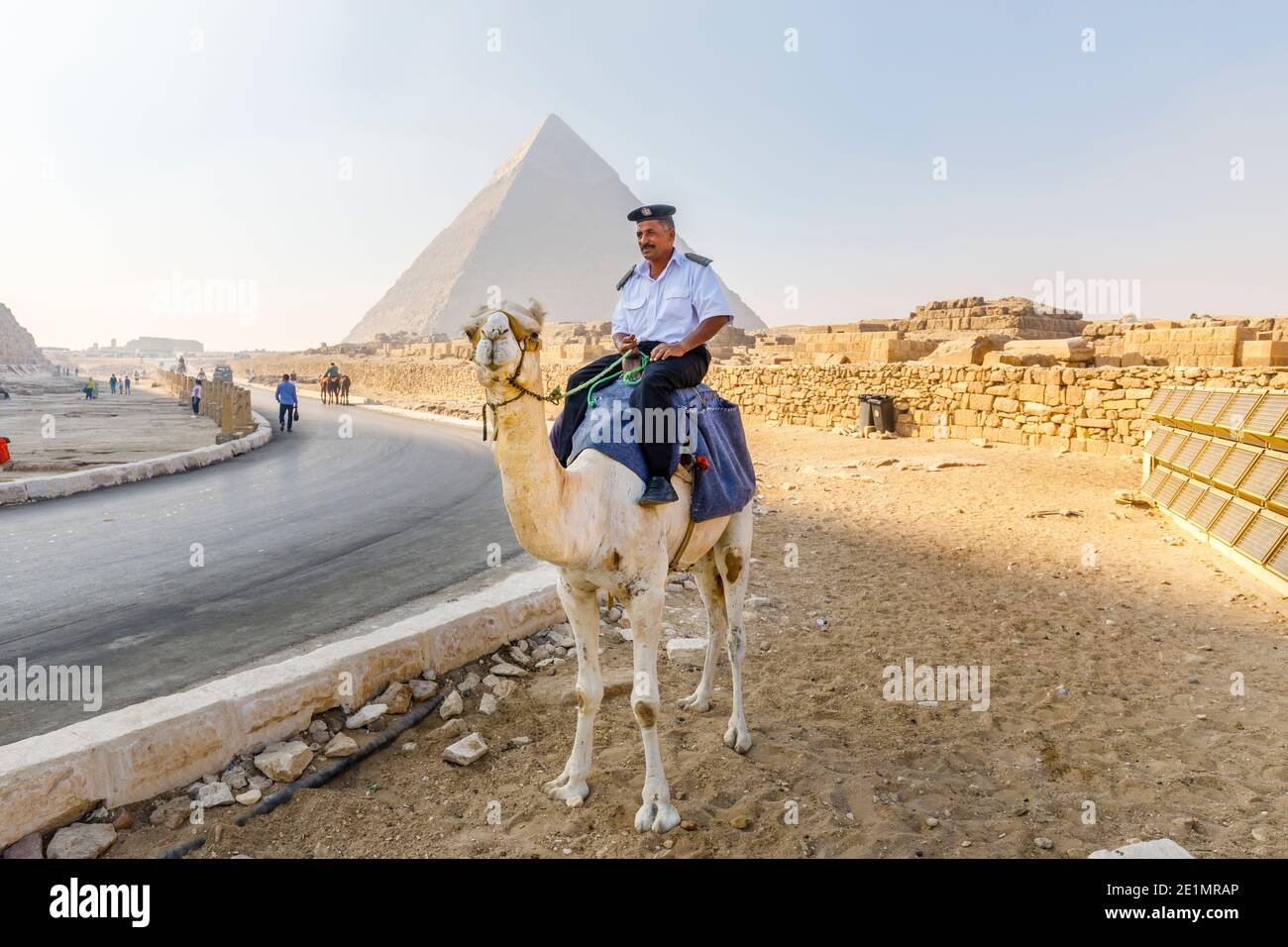 Policier local monté sur un chameau dans le complexe de la pyramide de Giza (nécropole de Giza) en face de la pyramide de Khafre, le Caire, Egypte Banque D'Images