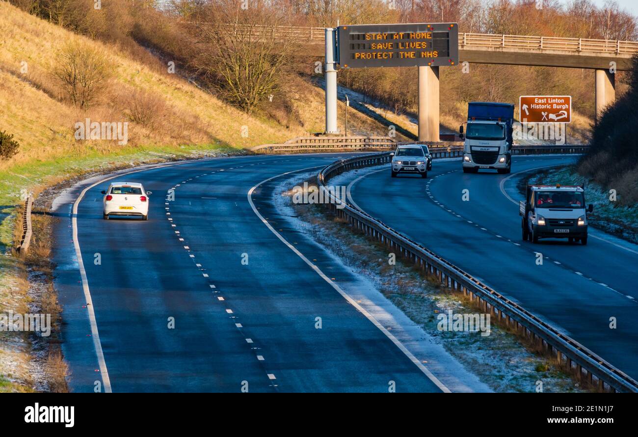 East Lothian, Écosse, Royaume-Uni, 8 janvier 2021. A1 LockDown 2 slogans : le statif aérien à double chaussée affiche les mêmes messages Covid-19 qu'en avril lors du premier verrouillage écossais, mais dans un ordre légèrement différent : rester à la maison, sauver des vies, protéger le NHS. La circulation est plus perceptible qu'elle ne l'était lors du premier verrouillage lorsque cette partie de l'A1 était presque entièrement vide Banque D'Images