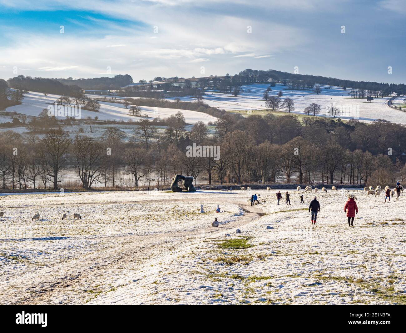 Deux formes de grande taille. Par Henry Moor, avec des moutons et des visiteurs dans un parc de sculptures du Yorkshire recouvert de neige. ROYAUME-UNI. Banque D'Images