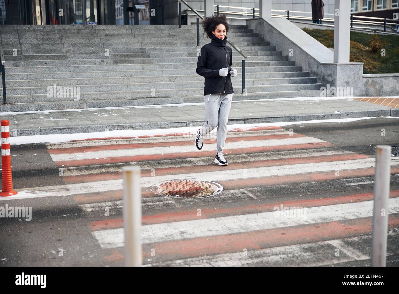 Une personne qui fait du jogging traverse une traversée Banque D'Images