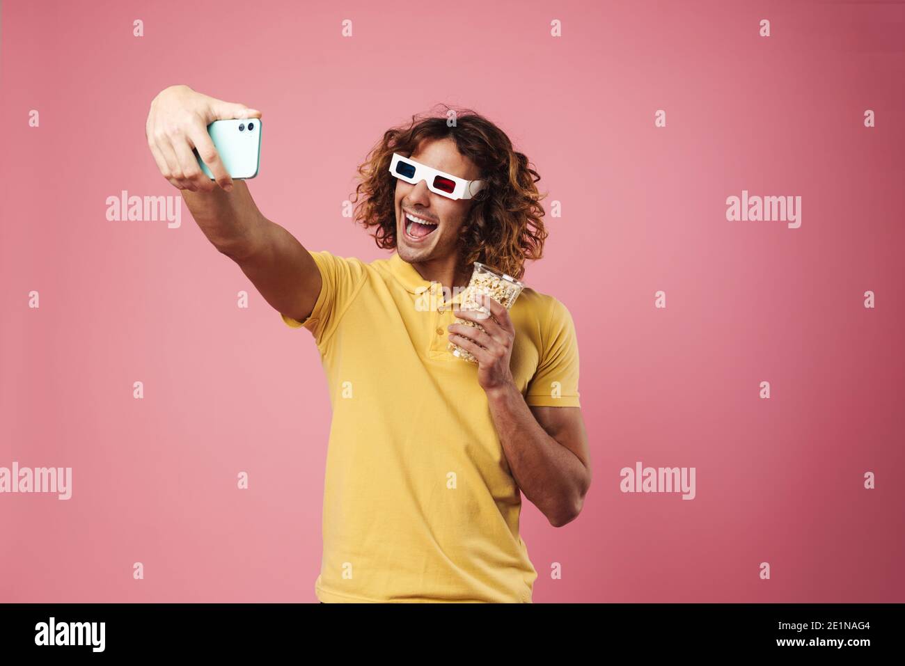 Un gars adorable et enthousiaste en lunettes 3d qui prend le selfie avec du  pop-corn sur téléphone cellulaire isolé sur fond rose Photo Stock - Alamy
