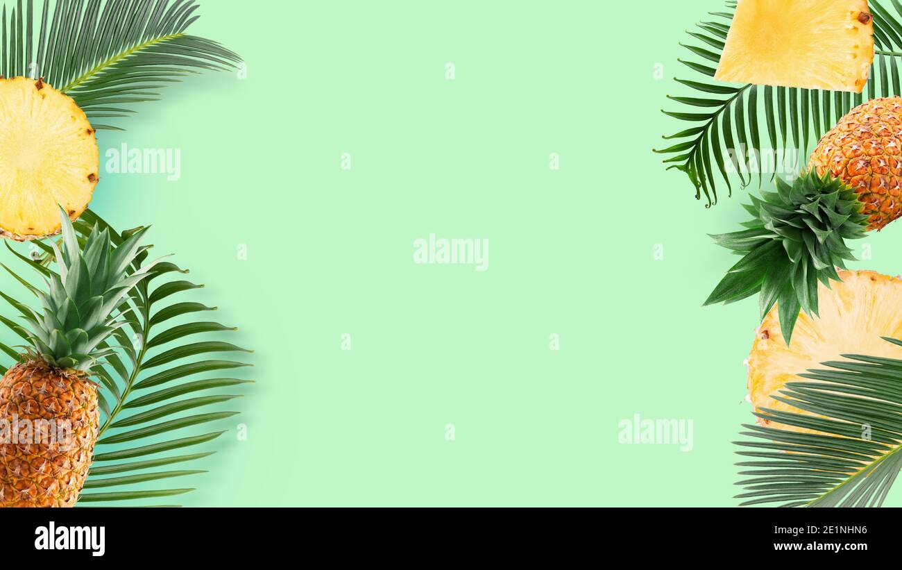 motif avec des tranches d'ananas et d'ananas et des feuilles de palmier sur fond vert menthe. Banque D'Images