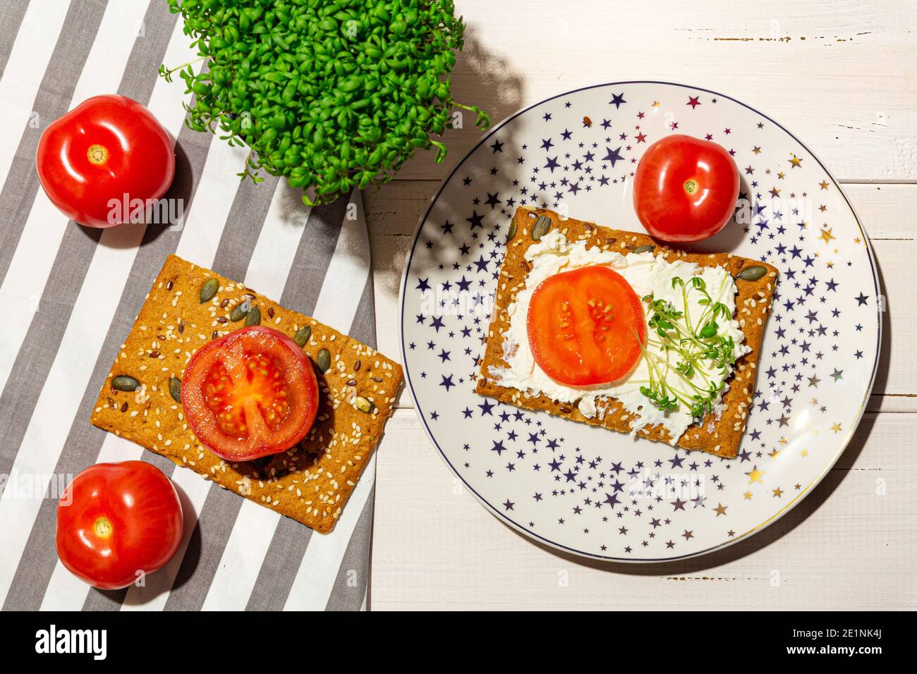 Sandwich avec fromage doux, tomates, microverts sur l'assiette. Pose à plat. Banque D'Images