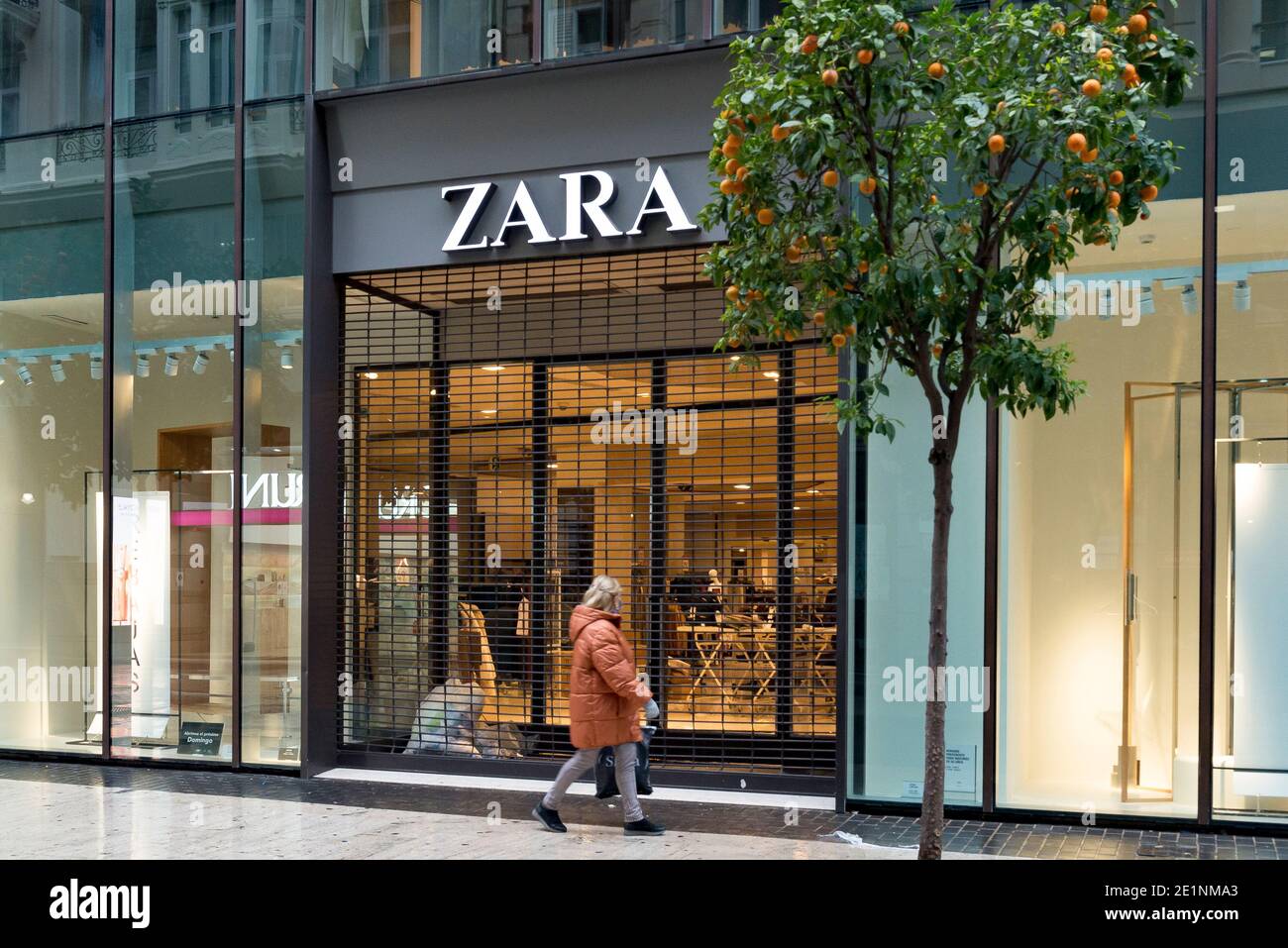 Une femme portant un masque de visage marche devant un magasin Zara  fermé.dans les dernières semaines de Noël, les cas de Covid19 à Valence ont  augmenté, ce qui a entraîné les ventes