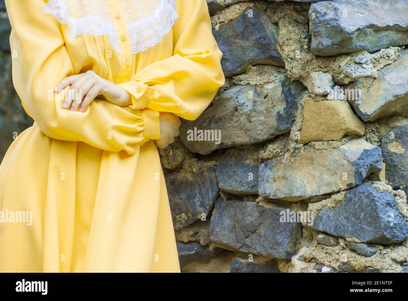 Fille en robe avec couleur Pantone illuminant sur Ultimate Gray mur de pierres Banque D'Images