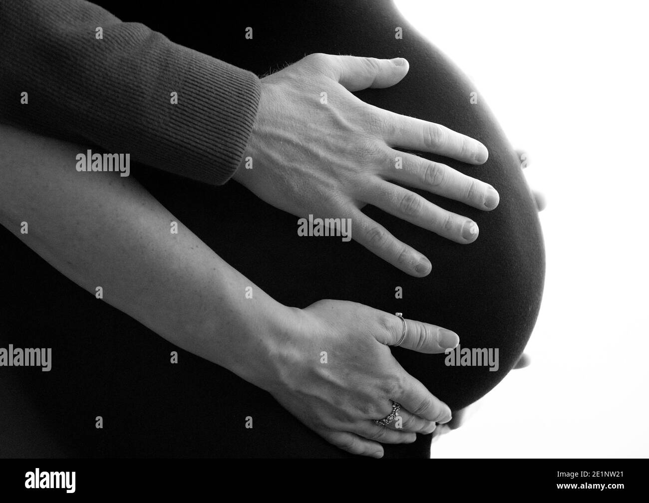 Femmes enceintes avec partenaire tenant sur la bosse. Banque D'Images