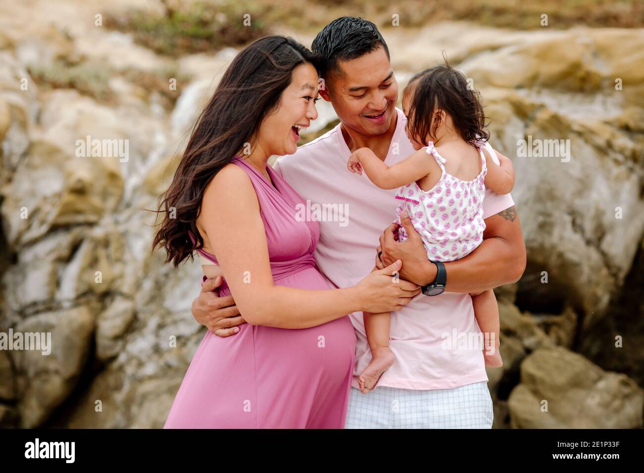 Femme asiatique enceinte et mari extatique tenant une jeune fille Photo  Stock - Alamy