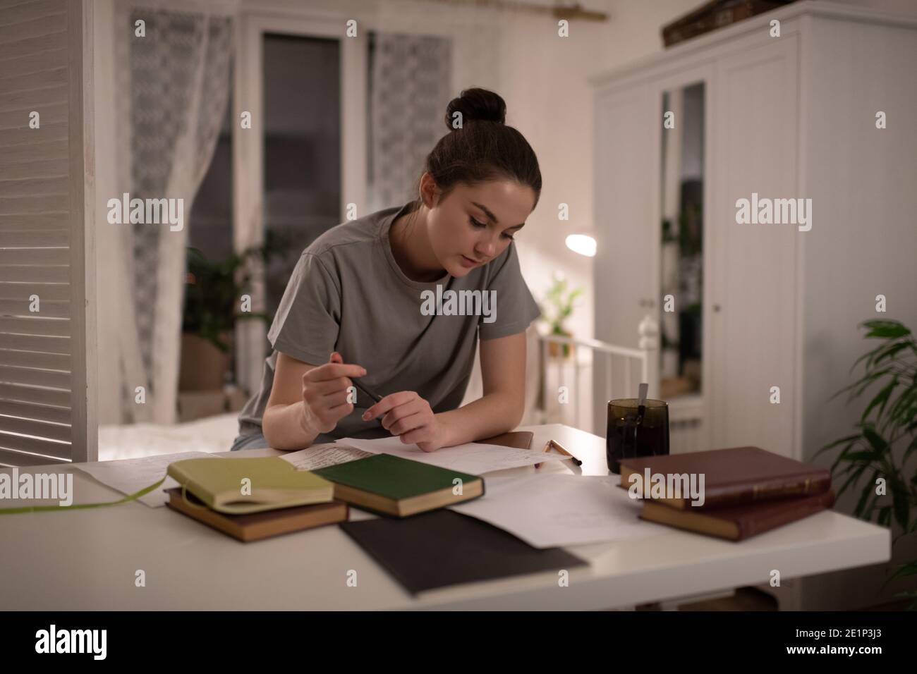Une étudiante intelligente assise et lisant des notes préparant le travail etudes Banque D'Images