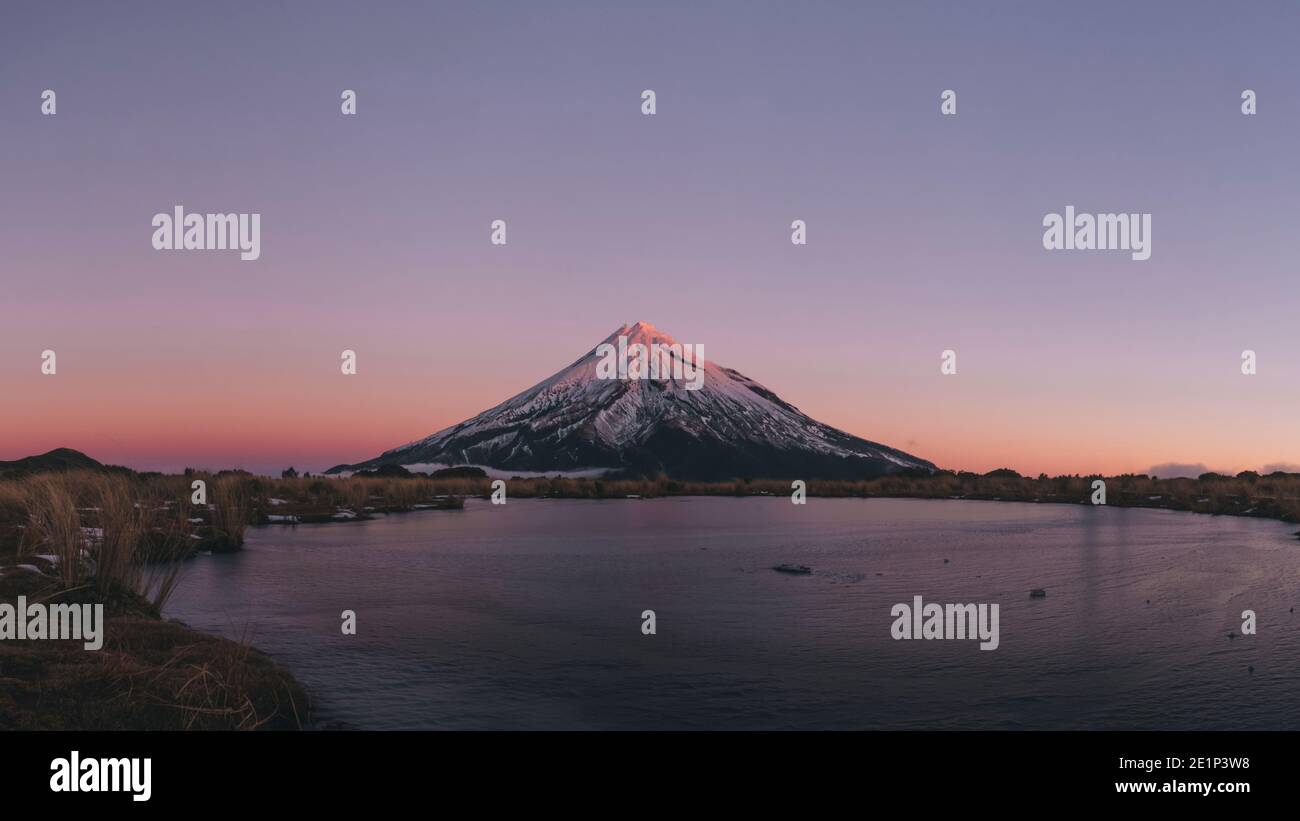 Lac gelé au pied du Mont Taranaki pendant la fin du coucher du soleil, Nouvelle-Zélande. Banque D'Images