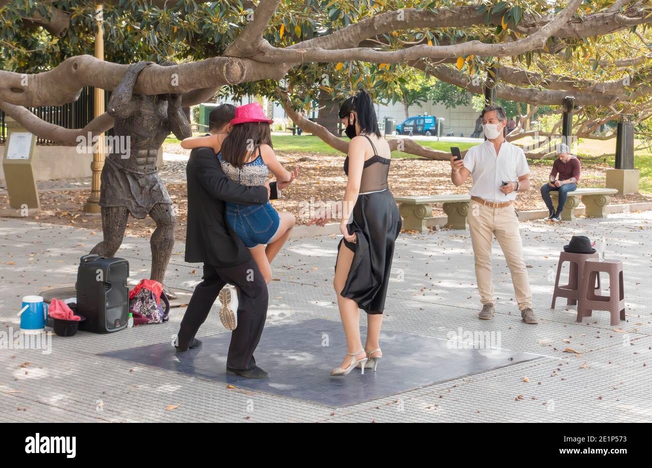 Les touristes avec des masques de visage posent avec des danseurs de tango de rue avec des masques de visage pendant la pandémie Covid-19 à Recoleta, Buenos Aires, Argentine Banque D'Images