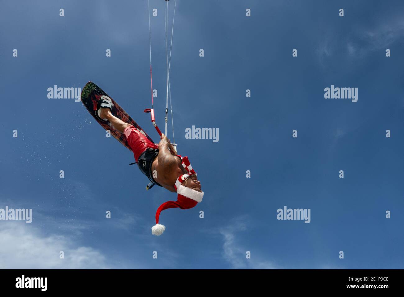 Le kitesurfer professionnel du Père Noël passe les vagues de mer et survole eau Banque D'Images