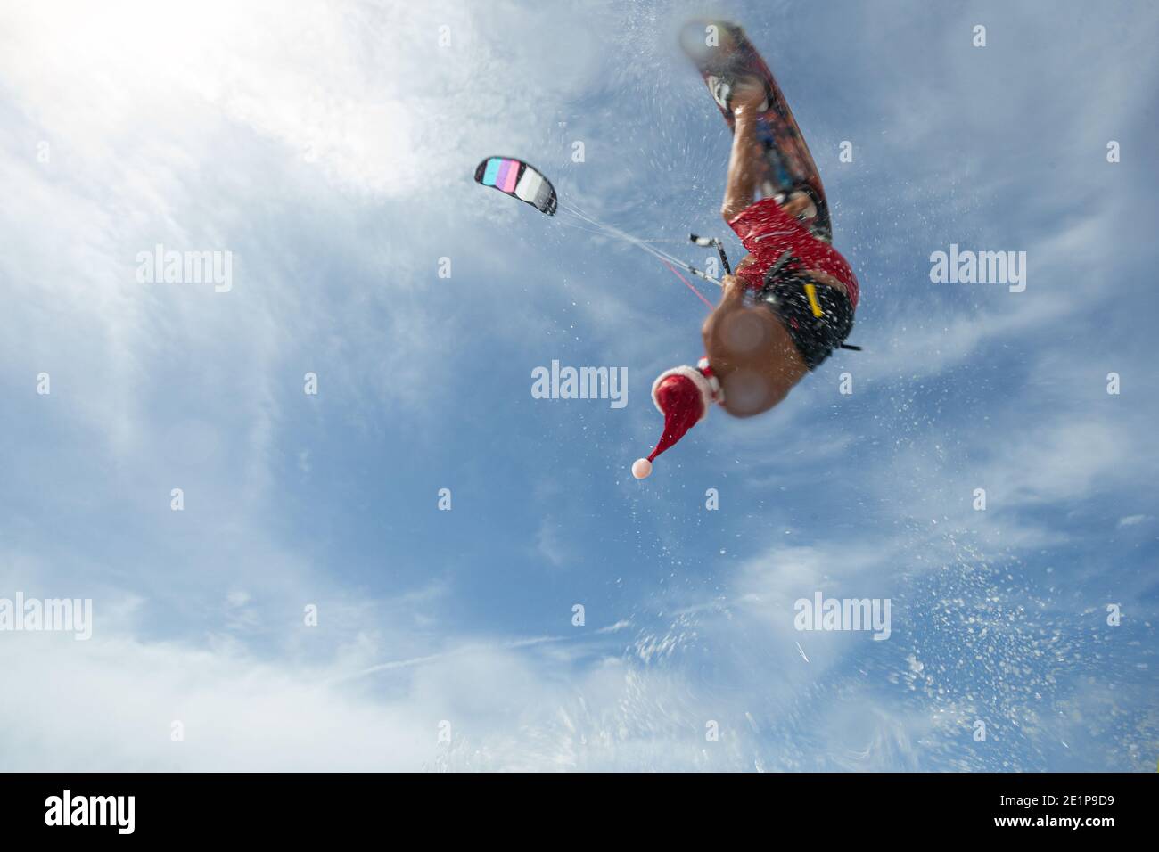 Le kitesurfer professionnel du Père Noël passe les vagues de mer et survole eau Banque D'Images