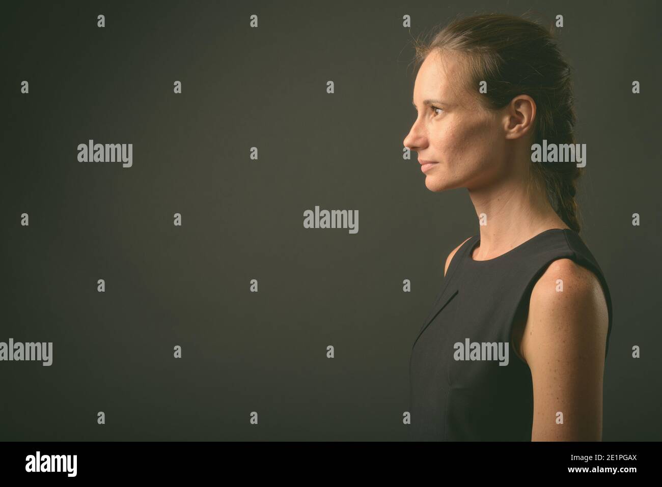 Portrait de femme belle contre l'arrière-plan gris Banque D'Images