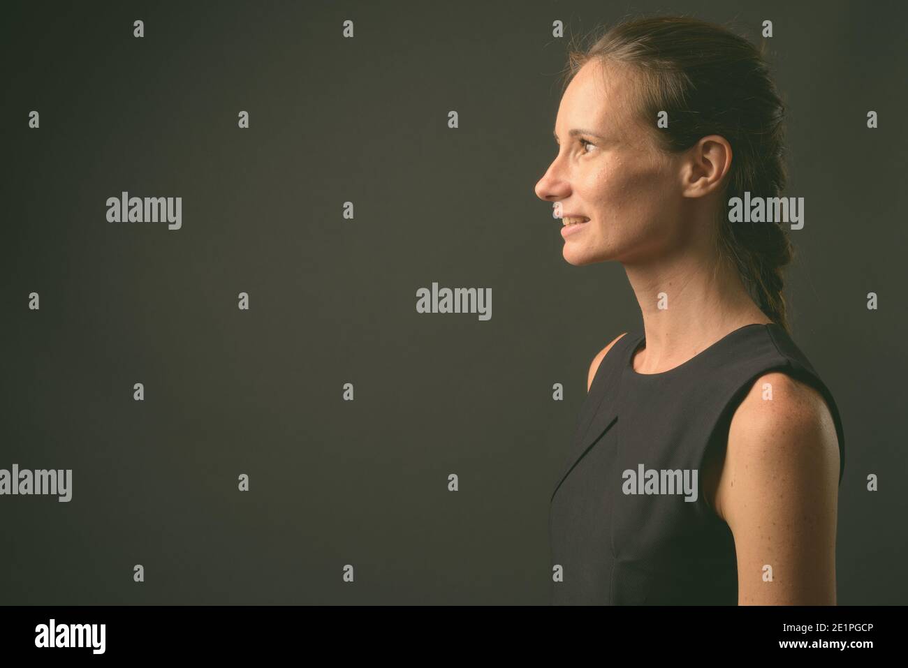 Portrait de femme belle contre l'arrière-plan gris Banque D'Images