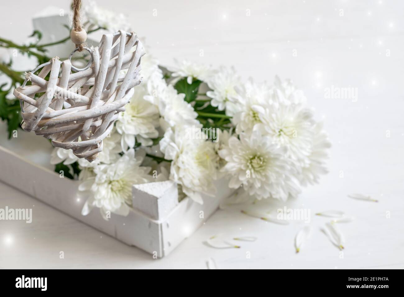 Paille blanche zéro coeur de déchets suspendu au-dessus du bouquet de chrysanthème. Carte de vœux pour la Saint-Valentin ou la fête des mères, ou invitation à une fête. Banque D'Images