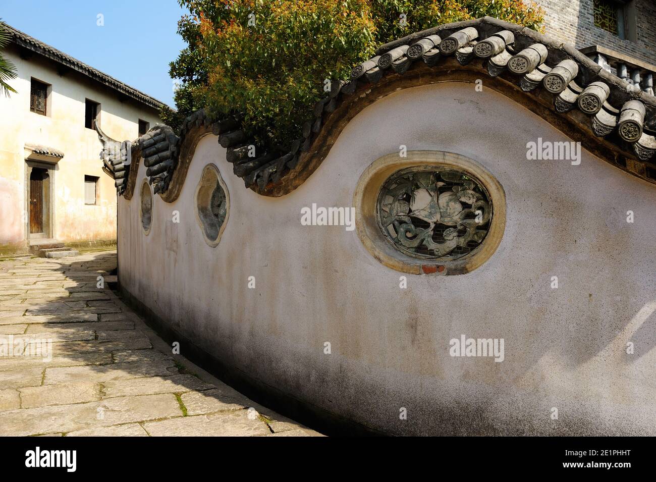 Ancienne rue avec un mur incurvé de style classique dans un vieux village pittoresque, typique de la Chine. Banque D'Images