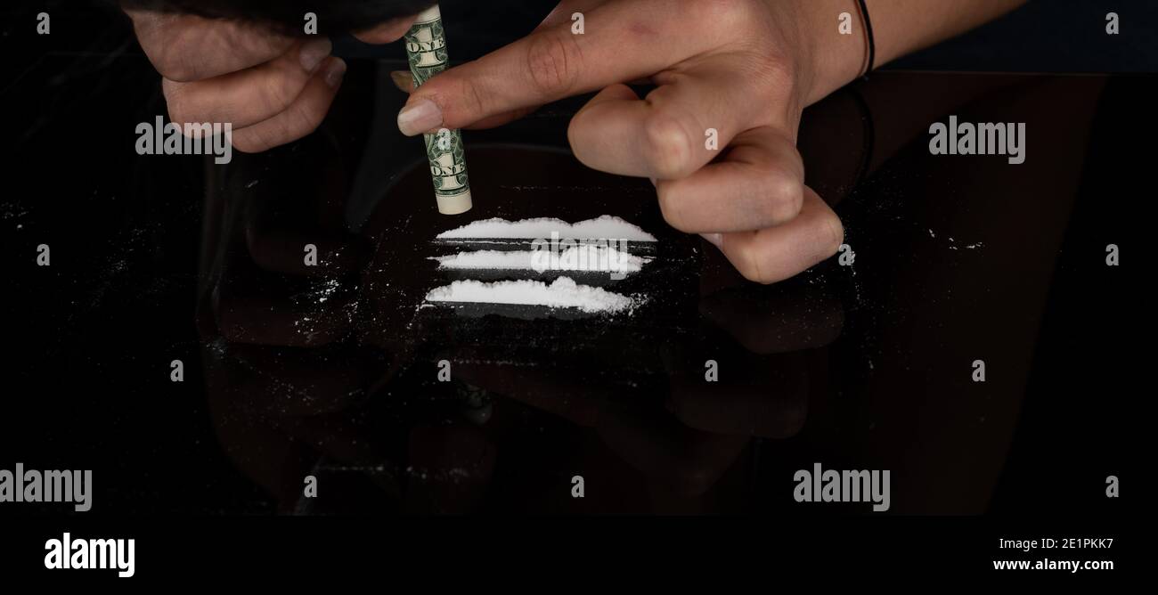 Drogue addicte femme ronflant la poudre de cocaïne avec roulée dollar billet. Concept de narcotiques. Gros plan macro. Prise de vue panoramique. Bannière Panorama. Haut r Banque D'Images