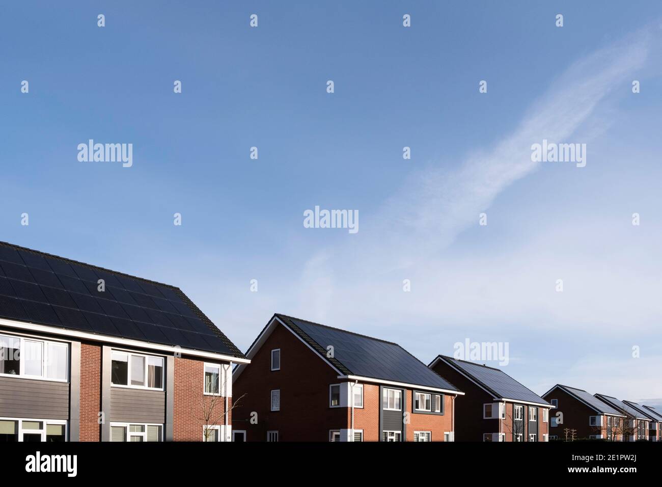 Panneaux solaires montés sur les toits d'une rangée de maisons modernes de nouvelle construction à Lemmer, Frise, pays-Bas avec ciel bleu Banque D'Images