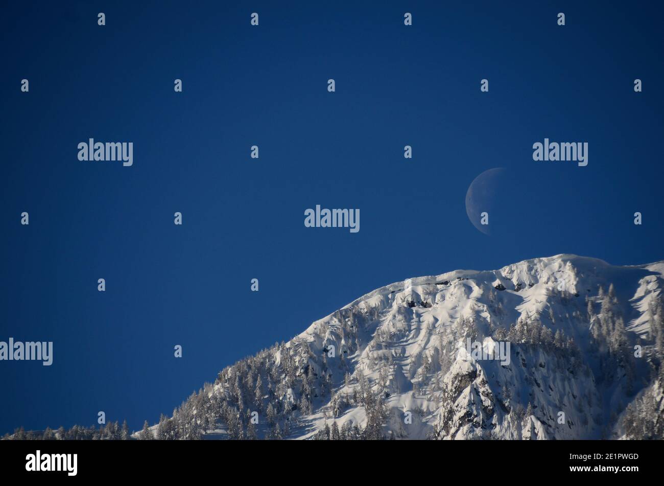 lune sur ciel bleu avec montagne enneigée Banque D'Images