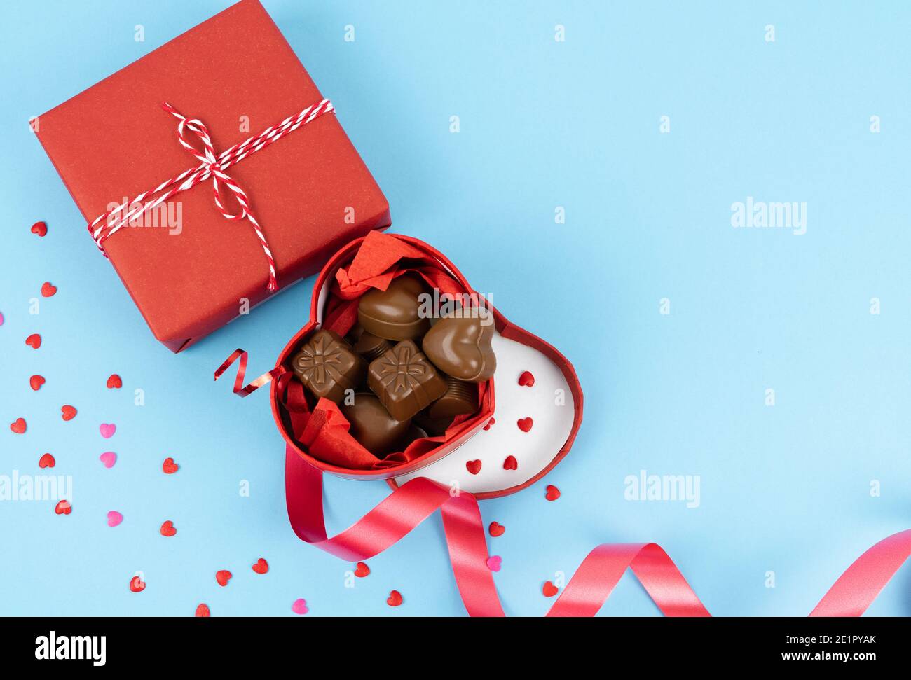 Boîte rouge en forme de coeur ouvert plein de chocolats sur fond bleu. Concept de la Saint-Valentin, anniversaire, fête des mères et anniversaire. COP Banque D'Images