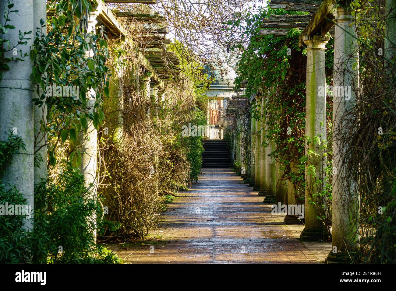 Colonnes en pierre bordant un chemin de briques. Partie de Hampstead Pergola sur la Heath. Banque D'Images