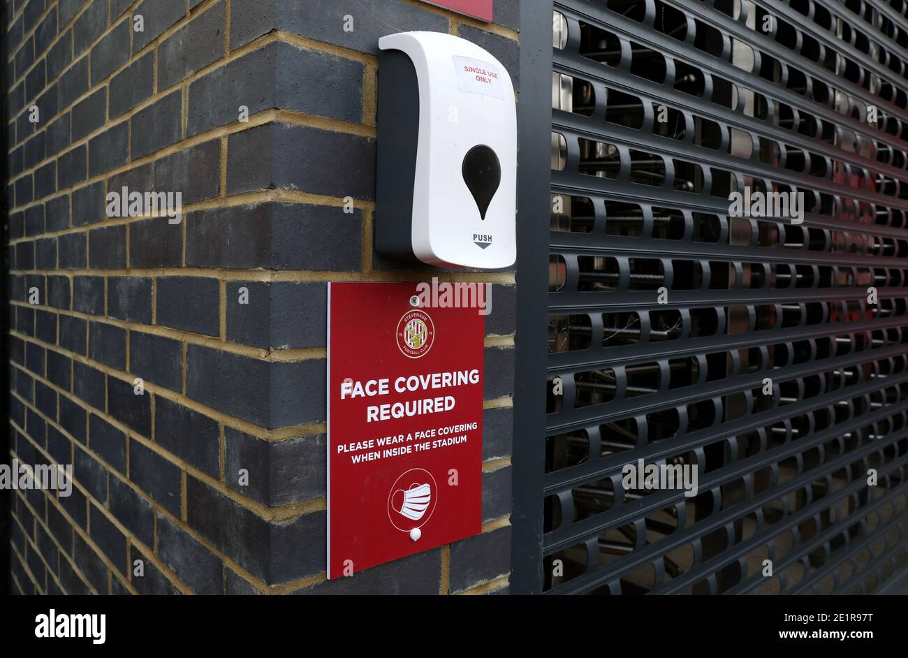 L'assainisseur pour les mains et la signalisation pour les revêtements faciaux sont visibles à l'extérieur du stade Lamex, avant le troisième match de la coupe Emirates FA au stade Lamex, à Stevenage. Banque D'Images