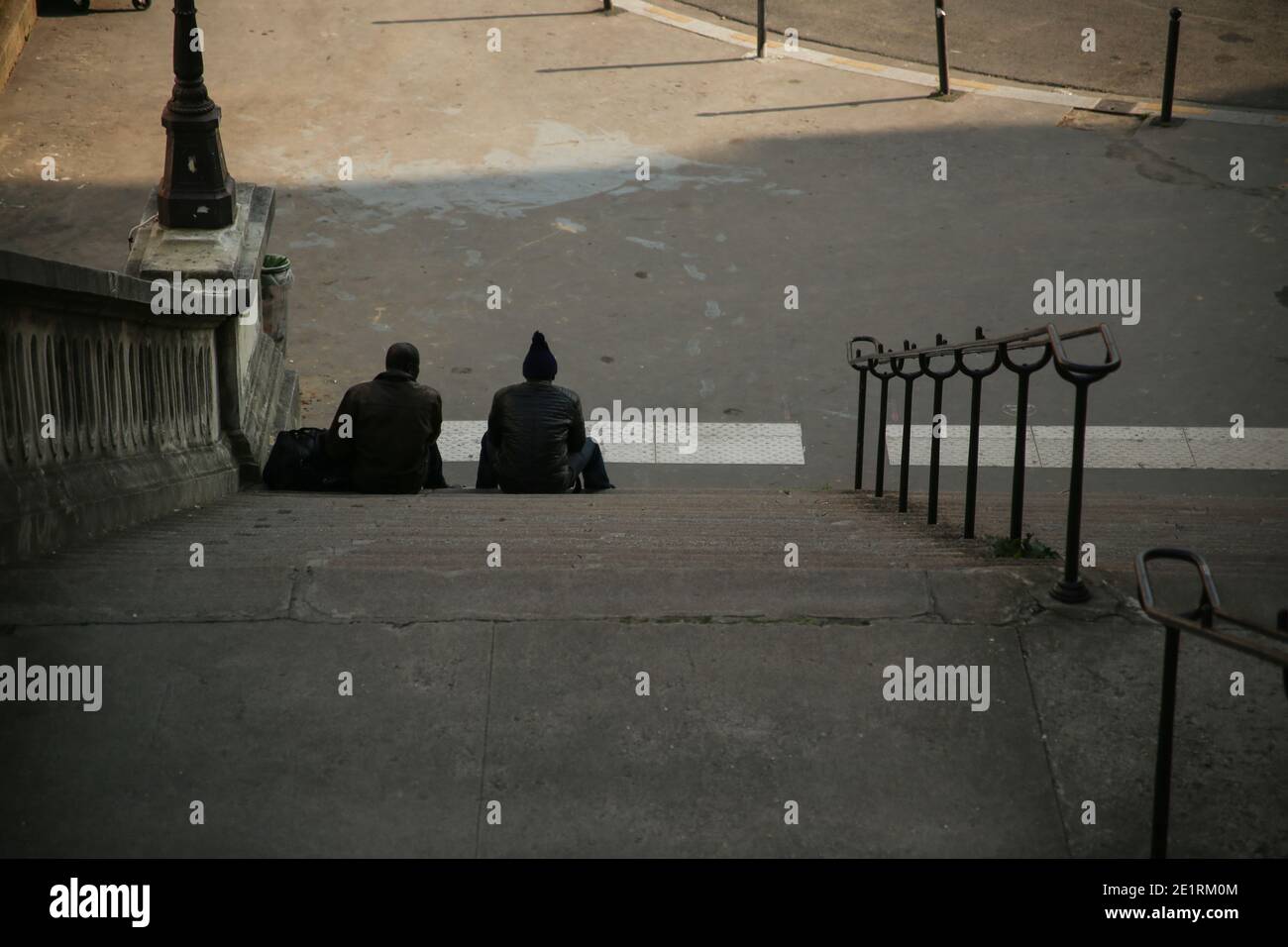 Deux hommes assis sur les marches de la ville à Paris. Banque D'Images