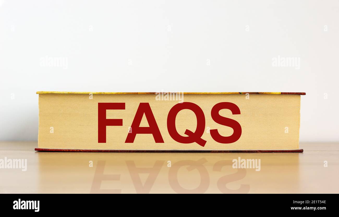 SYMBOLE FAQ, foire aux questions. Livre avec le mot 'FAQ, Foire aux questions' sur une belle table en bois, fond blanc. Business et F Banque D'Images