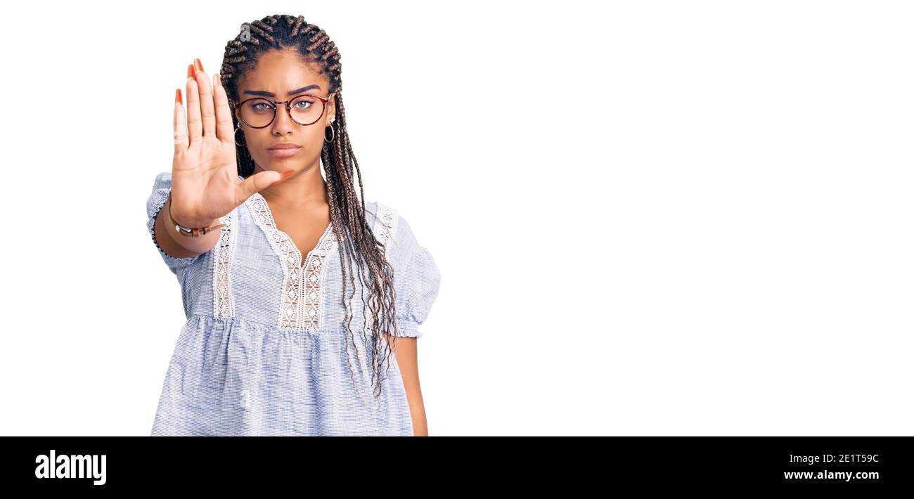 Jeune femme afro-américaine avec des tresses portant des vêtements et des lunettes décontractés d'été qui ne chantent plus avec la paume de la main. Avertissement expression avec nega Banque D'Images