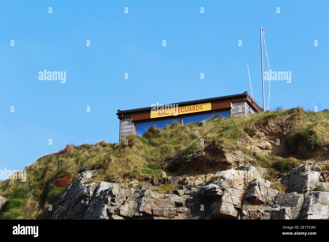 Une maison de sauveteurs RNLI au sommet d'une falaise surplombant Une plage à Cornwall en été Banque D'Images