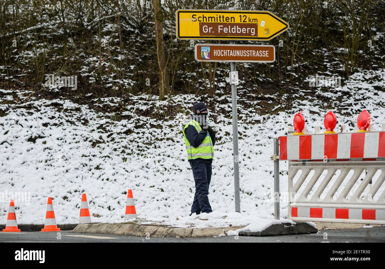 Schmitten, Allemagne. 09e janvier 2021. Un volontaire du Verkehrswacht Obertaunus se tient à la Deutsche Limes Straße fermée à Oberursel/Hohemark. La région de Feldberg dans le Taunus est fermée en raison de la neige cassée et pour éviter une attaque d'excursions d'hiver. Le sommet est uniquement accessible sans motorisation. Credit: Andreas Arnold/dpa/Alay Live News Banque D'Images