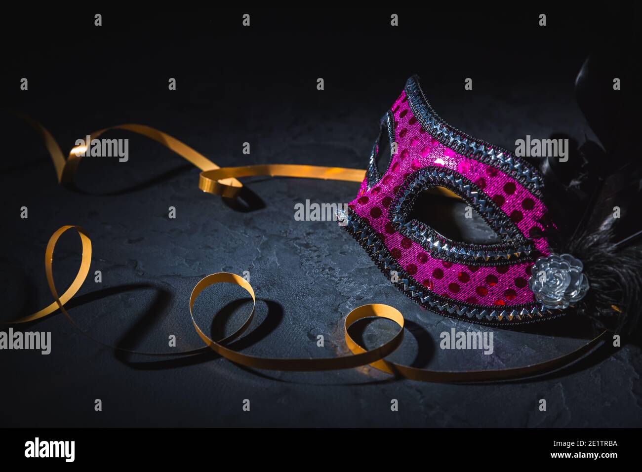Masque de carnaval avec ruban doré sur fond noir Banque D'Images