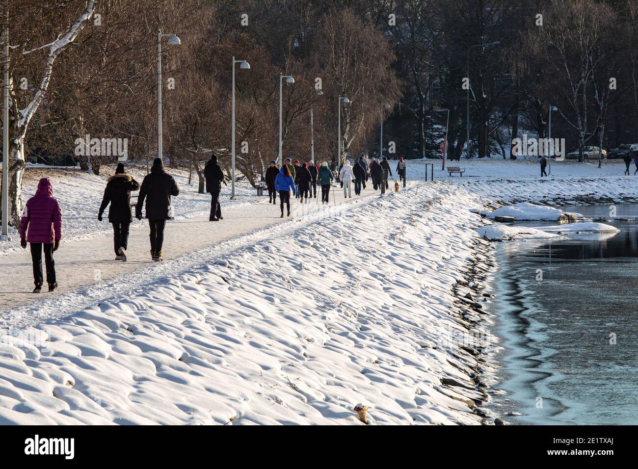 Personnes ayant une promenade le jour d'hiver dans la baie d'Humalahti dans le quartier de Taka-Töölö à Helsinki, en Finlande Banque D'Images