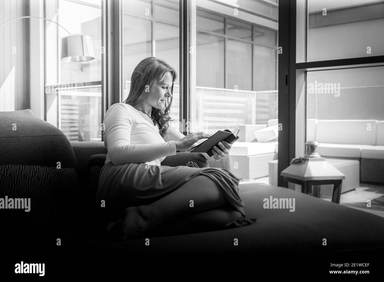 très belle femme d'âge moyen ayant un matin calme et apprécier son café tout en lisant Banque D'Images