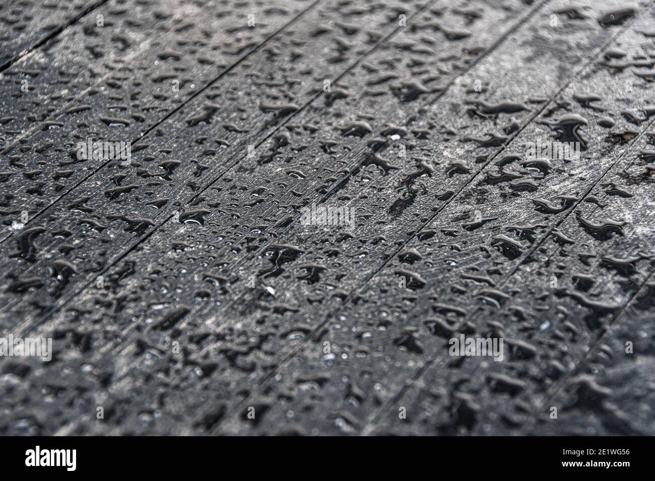 Gouttes d'eau sur la surface noire de la table en bois Banque D'Images