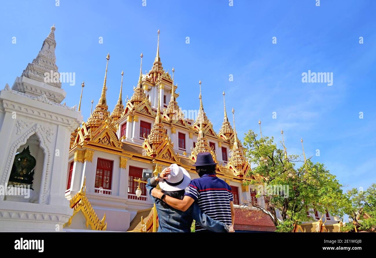 Couple impressionné par l'incroyable Loha Prasat (château de fer) qui orne 37 Spires d'or à l'intérieur du temple de Wat Ratchanatdaram, Bangkok, Thaïlande Banque D'Images
