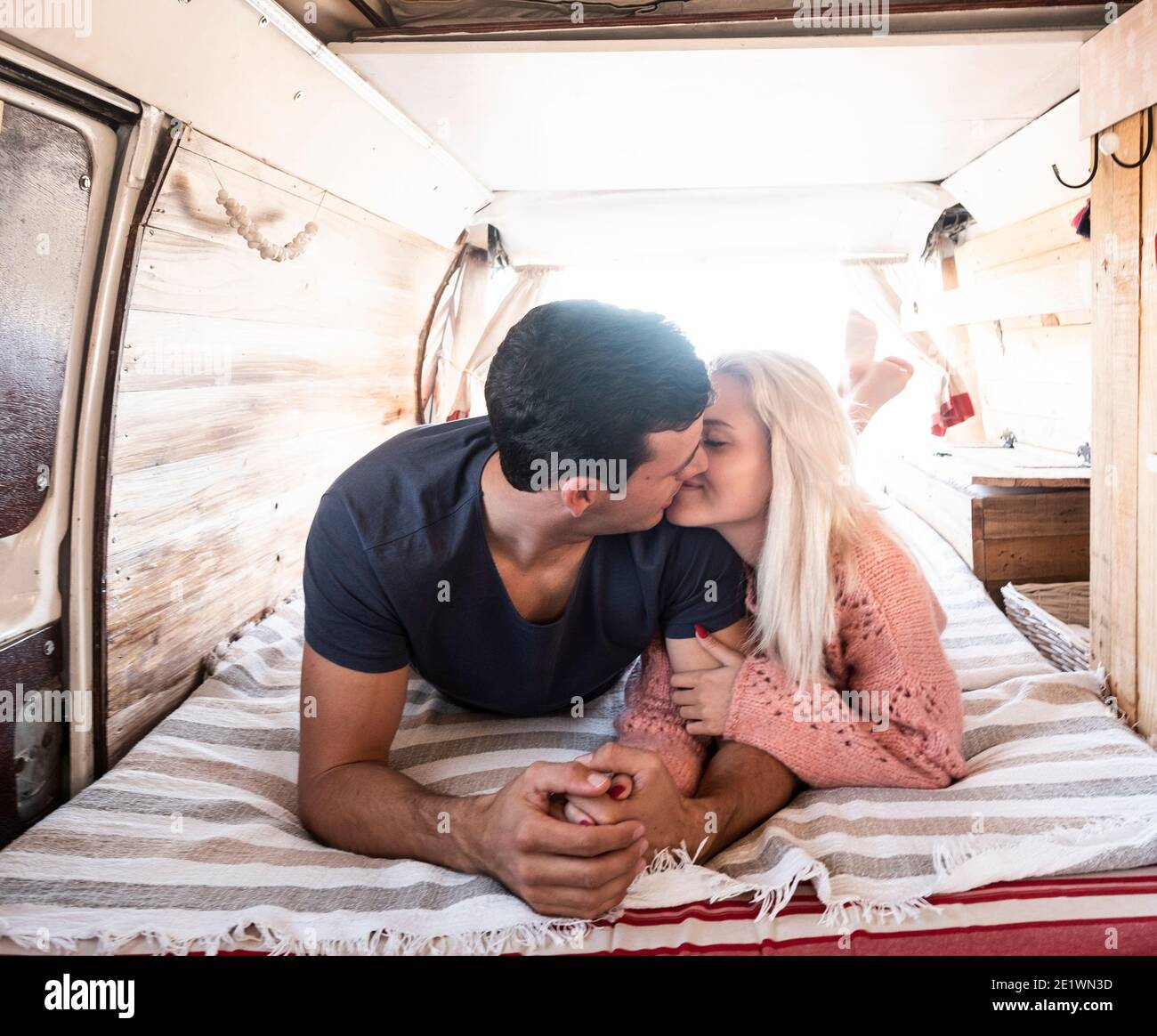 Amour et voyage avec le baiser et l'amour de jeunes couples caucasiens à l'intérieur d'une fourgonnette branchée pendant la vie ou les vacances activité - concept de personnes tog Banque D'Images