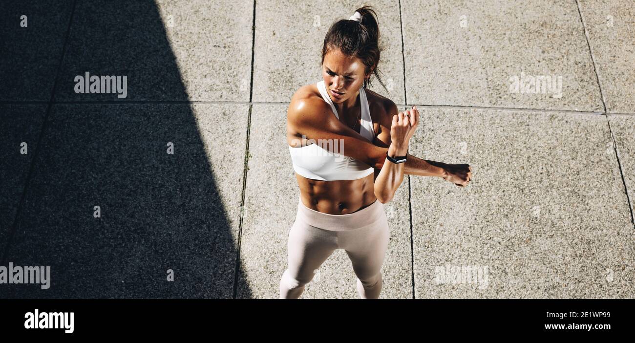 Vue de dessus prise de vue grand angle d'un bras d'étirement sportswoman. Femme faisant des exercices d'échauffement. Banque D'Images
