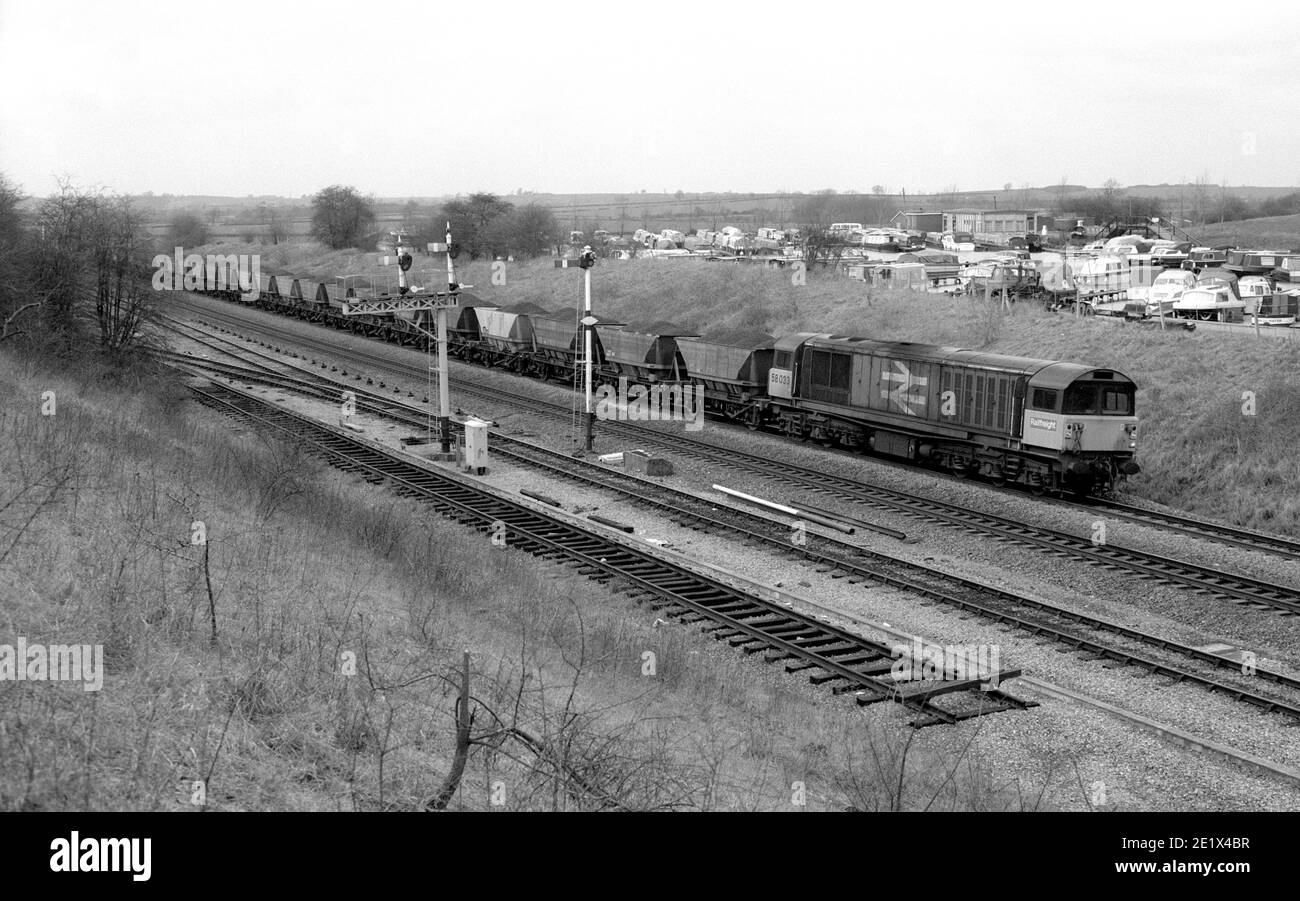 La locomotive diesel n° 58033 de classe 58 dirige un train de charbon MGR jusqu'à la centrale électrique de Didcot à Fenny Compton, Warwickshire, Royaume-Uni. 1987 Banque D'Images