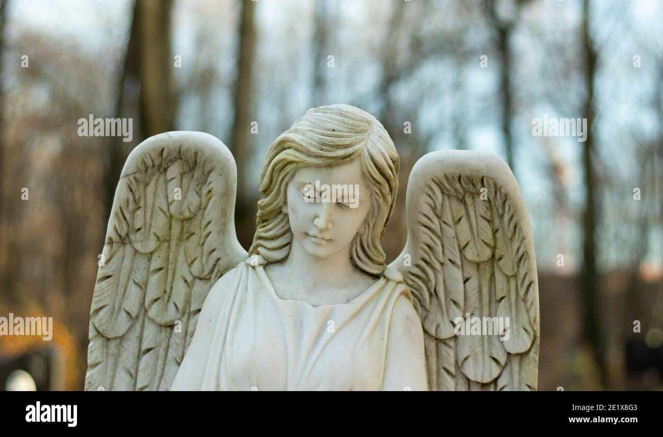 Ange femelle blanc marbre avec ailes et arrière-plan flou. Banque D'Images