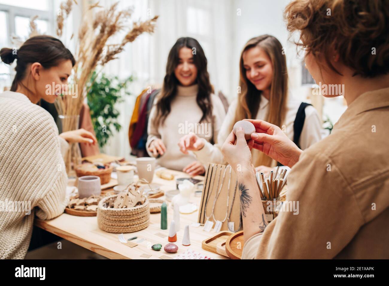 Quatre femmes en magasin écologique de cueillette et de discuter divers cosmétiques produits Banque D'Images