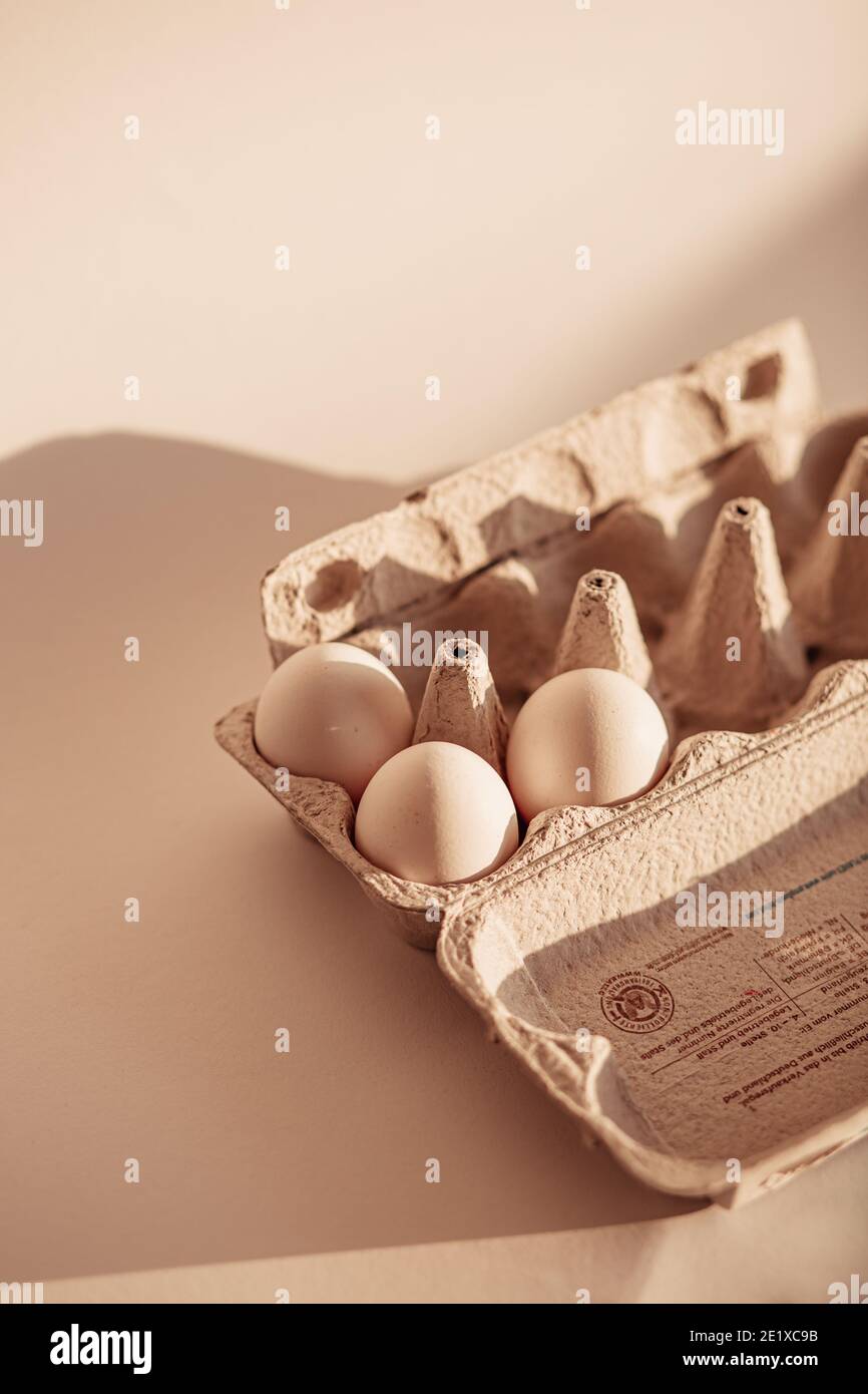Oeufs blancs dans le carton d'oeufs sur fond neutre (nature morte alimentaire) Banque D'Images Oeufs blancs dans le carton d'oeufs sur fond neutre (nature morte alimentaire) Banque D'Images