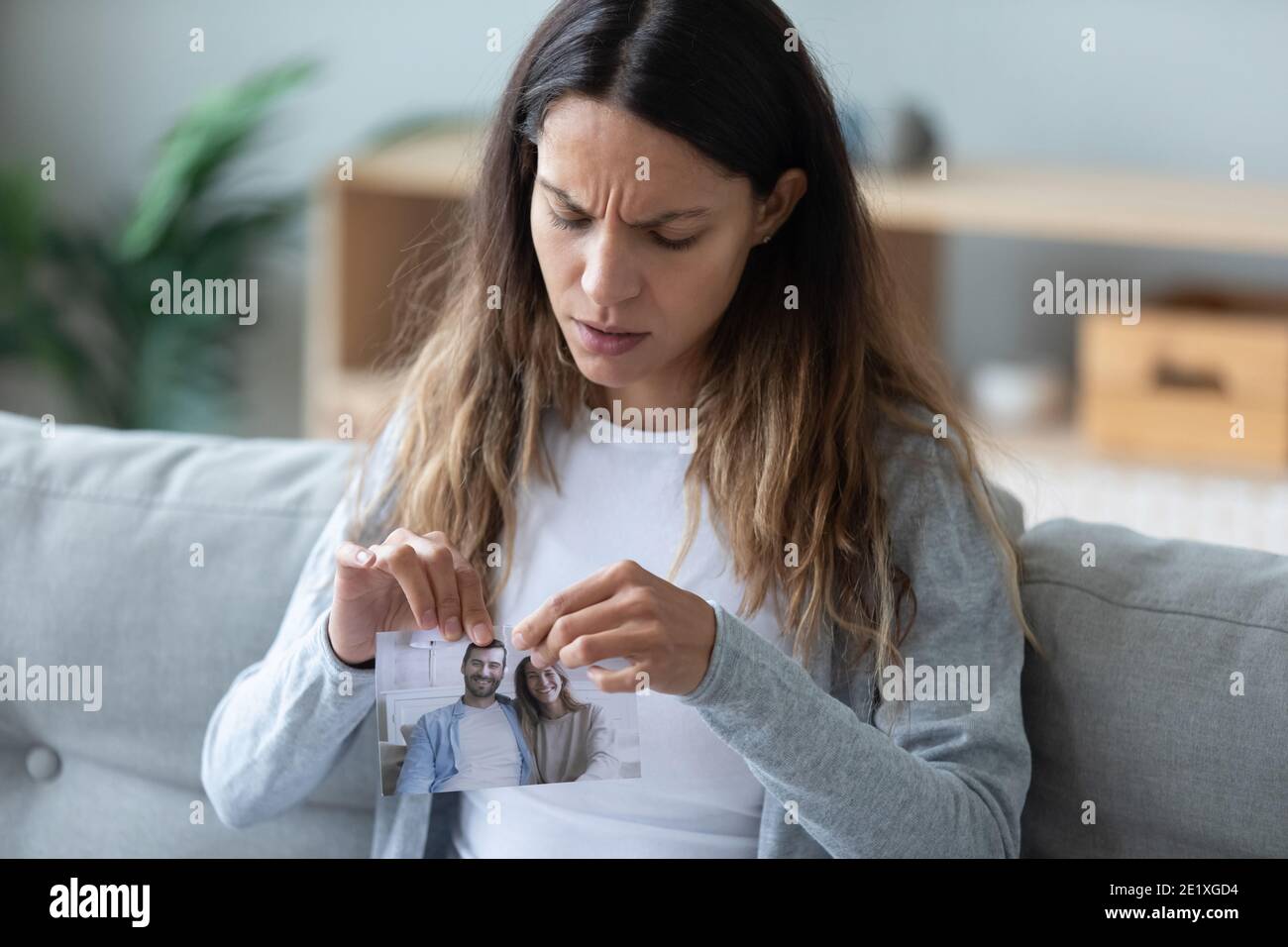 Gros plan femme malheureuse déchirant l'image avec un petit ami, cassez Banque D'Images