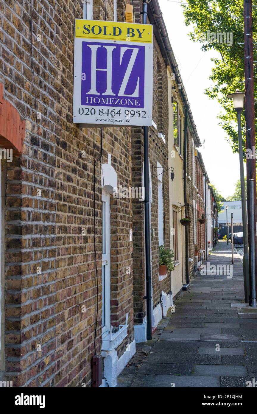 Affiche vendue sur la propriété dans une rue de petites maisons mitoyennes. Banque D'Images