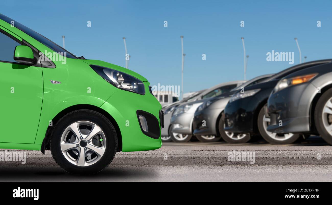 Voiture verte sur un fond de voitures dans une rangée Banque D'Images